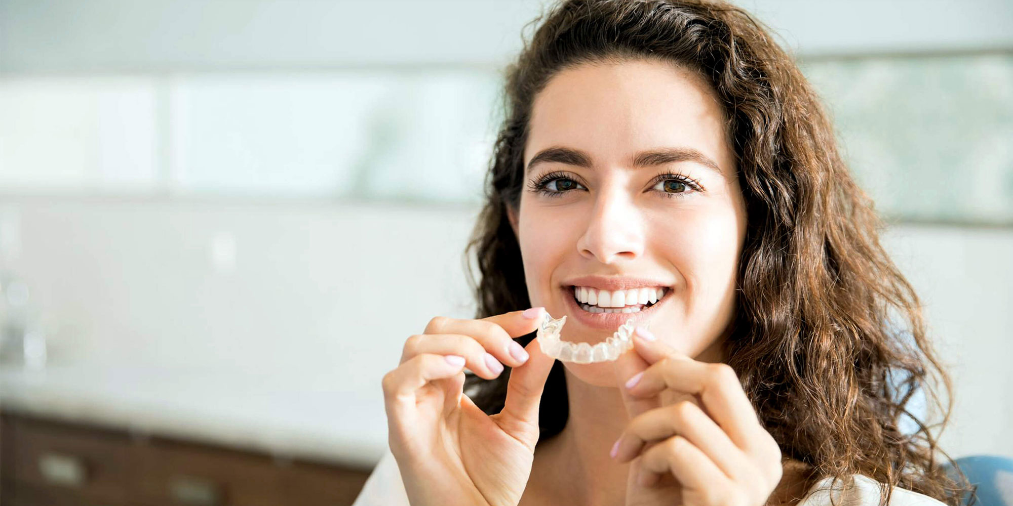 patient putting a invisalign in her mouth